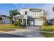 Two-story house with gray siding, stone accents, and a three-car garage at 1474 Olympic Club Blvd, Champions Gate, FL 33896