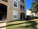 Tan building exterior with stairs, balconies, and landscaping at 2306 Silver Palm Dr # 103, Kissimmee, FL 34747