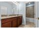 Dual vanity with wood cabinetry and large mirror at 2731 Flintlock Ave, Clermont, FL 34711