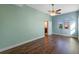 Bedroom with light green walls, wood laminate floors, double doors, and windows at 2731 Flintlock Ave, Clermont, FL 34711