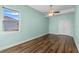 Spacious bedroom with wooden laminate floors, soft green walls, white trim, and ceiling fan at 2731 Flintlock Ave, Clermont, FL 34711