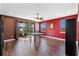 Bonus room with wood laminate floors, red accent wall, table, ceiling fan, and access to balcony at 2731 Flintlock Ave, Clermont, FL 34711