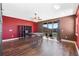 Bonus room featuring a bold red accent wall, wood-look floors, and access to a balcony at 2731 Flintlock Ave, Clermont, FL 34711