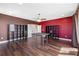 Bonus room with bold red accent wall, built-in shelves, and wood laminate floors at 2731 Flintlock Ave, Clermont, FL 34711