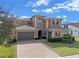 Stunning two-story home with a paver driveway and lush landscaping at 2731 Flintlock Ave, Clermont, FL 34711
