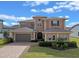 Beautiful two-story home with a paver driveway and landscaped yard at 2731 Flintlock Ave, Clermont, FL 34711