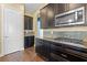 Kitchen with dark cabinets, stainless steel appliances, and mosaic tile backsplash at 2731 Flintlock Ave, Clermont, FL 34711