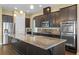 Kitchen with granite countertops, dark cabinets, and stainless steel appliances at 2731 Flintlock Ave, Clermont, FL 34711