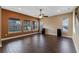 Living room with wood-look tile, ceiling fan, and large windows overlooking backyard at 2731 Flintlock Ave, Clermont, FL 34711