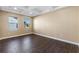 Bright living room with wood-look tile flooring, coffered ceiling, and large windows at 2731 Flintlock Ave, Clermont, FL 34711