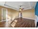 Spacious main bedroom with wood floors, ceiling fan, and door to balcony at 2731 Flintlock Ave, Clermont, FL 34711