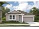 Single-story home with gray siding, light-blue accents, and a two-car garage at 5723 Cattle Ranch Dr, Saint Cloud, FL 34771