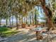 Tranquil backyard with a stone patio, unique table, and lush landscaping at 6320 Rocky Point Rd, Lake Wales, FL 33898
