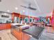 Modern kitchen with orange cabinets, large island, and stainless steel appliances at 6320 Rocky Point Rd, Lake Wales, FL 33898