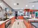 Modern kitchen with orange cabinets, stainless steel appliances, and a large island at 6320 Rocky Point Rd, Lake Wales, FL 33898