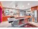 Modern kitchen with orange cabinets, a large island, and stainless steel appliances at 6320 Rocky Point Rd, Lake Wales, FL 33898