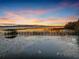 Scenic lake view at sunset with a private dock and calm water at 6320 Rocky Point Rd, Lake Wales, FL 33898