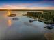 Aerial view of lake with docks at sunset reflecting in the water at 6320 Rocky Point Rd, Lake Wales, FL 33898