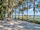 Sandy lakeshore with dock and lush trees at 6320 Rocky Point Rd, Lake Wales, FL 33898