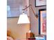 Nightstand with wall-mounted swing arm lamp and books at 6320 Rocky Point Rd, Lake Wales, FL 33898