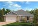 Attractive single-story home with stone accents, a two-car garage, and a landscaped front yard at 638 Meadows Edge Pl, Lake Wales, FL 33859