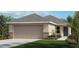 Attractive single-story home with a two-car garage and landscaped front yard at 8579 Caribbean Pine Way, Lakeland, FL 33809
