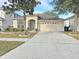 One-story house with attached garage, landscaping, and a paved driveway at 12859 Enclave Dr, Orlando, FL 32837