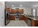Modern kitchen featuring stainless steel appliances and wood cabinetry at 1429 Moon Valley Dr, Champions Gate, FL 33896