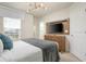 Modern bedroom with a TV, wooden dresser, and access to a bathroom at 1671 Kona Ln, Davenport, FL 33897