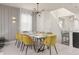 Dining area with modern table, yellow velvet chairs, and unique light fixture at 1671 Kona Ln, Davenport, FL 33897