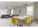 Dining area with a modern table, vibrant yellow chairs, and an adjacent living room at 1671 Kona Ln, Davenport, FL 33897