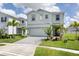 Inviting two-story home with a paved driveway, landscaped yard, and palm trees at 1671 Kona Ln, Davenport, FL 33897