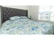Comfortable bedroom with a stylish headboard, floral bedding, and ample natural light at 328 Conway Ave, Saint Cloud, FL 34771