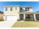 Inviting two-story home with a covered porch, landscaped yard, and attached two-car garage at 328 Conway Ave, Saint Cloud, FL 34771