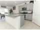 Modern kitchen with gray cabinets, stainless steel appliances, and an island with granite countertop at 328 Conway Ave, Saint Cloud, FL 34771