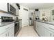 Bright kitchen featuring stainless steel appliances, gray cabinets, and granite countertops at 328 Conway Ave, Saint Cloud, FL 34771