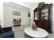 Living area with blue armchairs, white walls, a round glass-top coffee table, and framed artwork at 328 Conway Ave, Saint Cloud, FL 34771