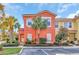 Two-story coral home with palm trees and landscaped yard at 4756 Ormond Beach Way, Kissimmee, FL 34746