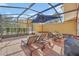 Spacious screened patio with lounge chairs and dining table at 4756 Ormond Beach Way, Kissimmee, FL 34746