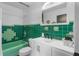 Retro bathroom featuring green tile, white vanity, and a bathtub at 507 Orange Ave, Ocoee, FL 34761