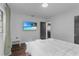 Comfortable bedroom with a wall-mounted TV, white bedding, and wood floors at 507 Orange Ave, Ocoee, FL 34761