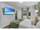 Inviting bedroom with a wall-mounted TV, wood floors, and green accents at 507 Orange Ave, Ocoee, FL 34761