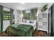 Cozy bedroom with green bedding, wood floors, and ample natural light at 507 Orange Ave, Ocoee, FL 34761