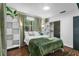 Well-lit bedroom with green bedding, functional storage, and wood floors at 507 Orange Ave, Ocoee, FL 34761