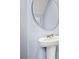Small powder room with pedestal sink and round mirror at 1210 Balsam Dr, Davenport, FL 33837