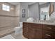 Bathroom with shower, toilet, and brown vanity at 1239 Radiant St, Reunion, FL 34747
