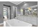 Upscale bathroom with a soaking tub, double vanities, and access to bedroom at 1239 Radiant St, Reunion, FL 34747