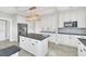 Modern white kitchen with stainless steel appliances, granite countertops, and an island at 451 Seminole St, Clermont, FL 34711