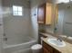 Bright bathroom featuring wood vanity, tiled floors, and shower/tub combo at 6129 Metrowest Blvd # 106, Orlando, FL 32835