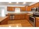 Modern kitchen with wood cabinets and stainless steel appliances at 8653 Se 162Nd St, Summerfield, FL 34491